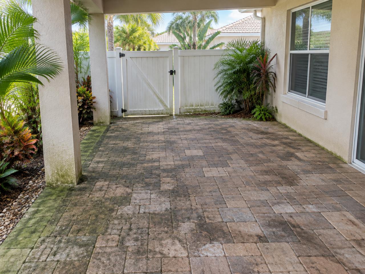 Weather-stained South Florida paver patio before pressure cleaning